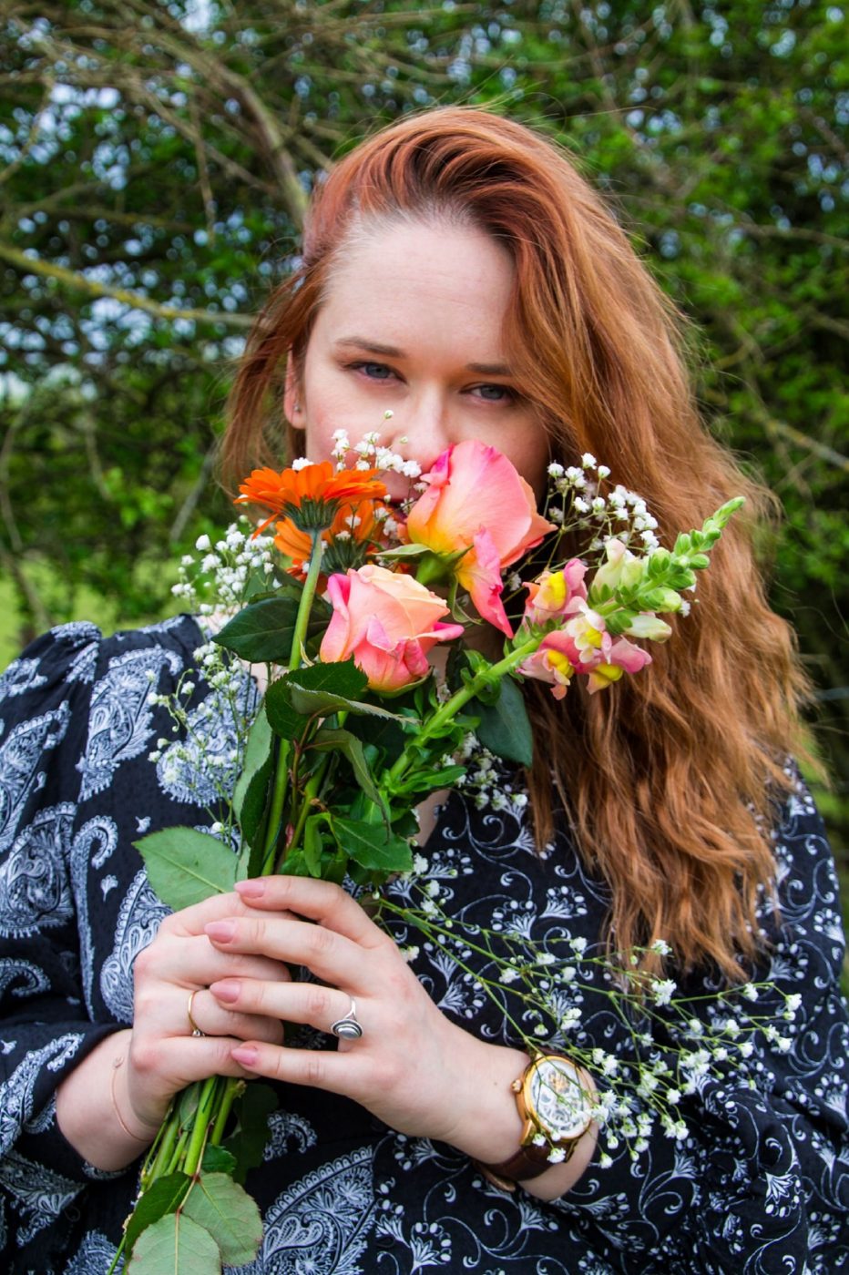 Hannah Collins peeking over a bouquet