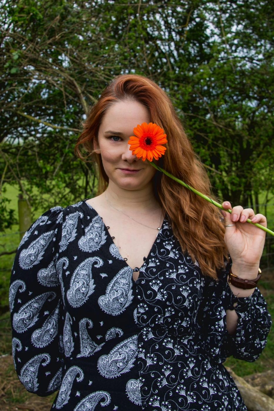 Hannah Collins holding a gerbera over one eye