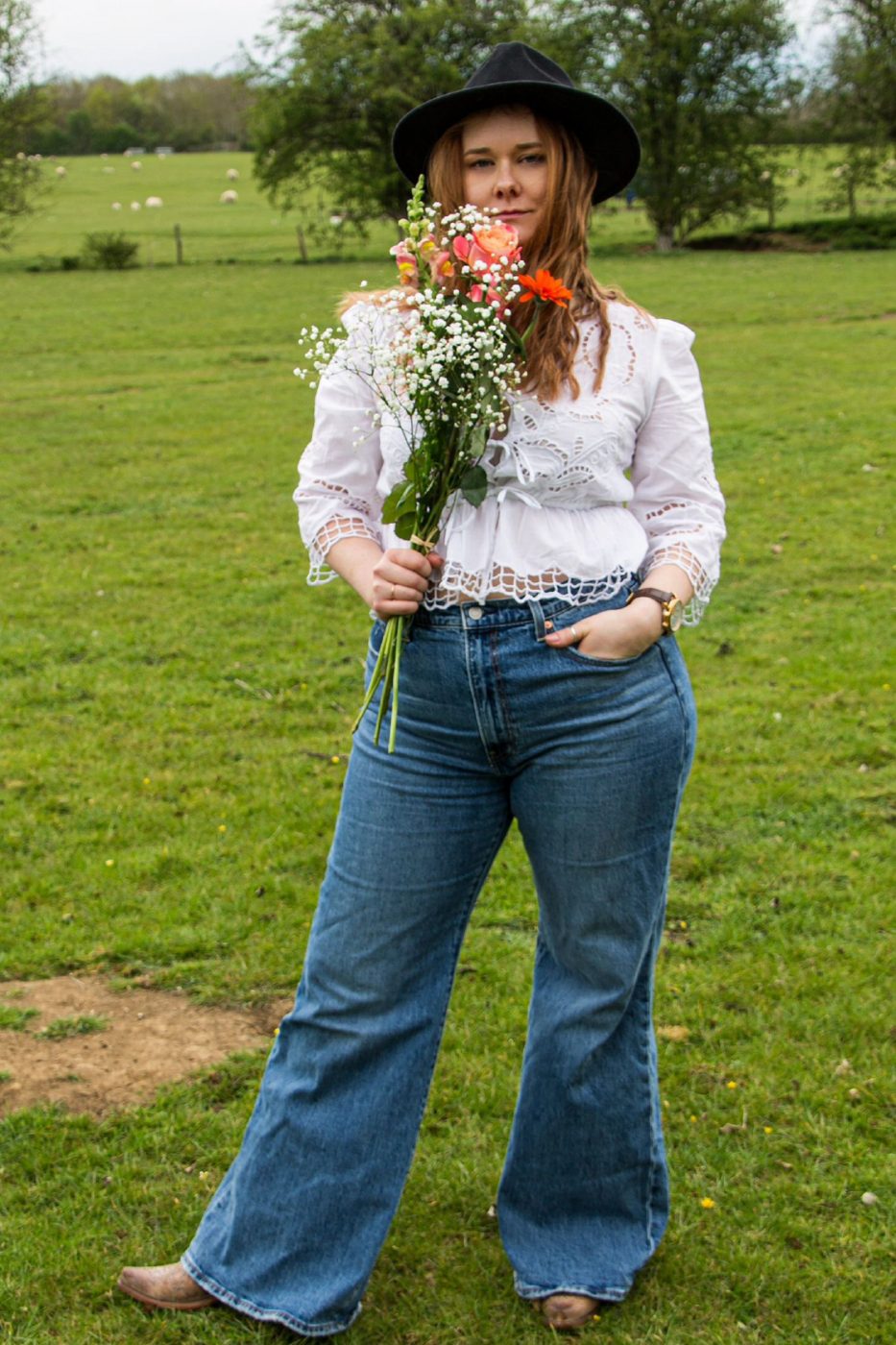 Hannah Collins holding flowers in a field